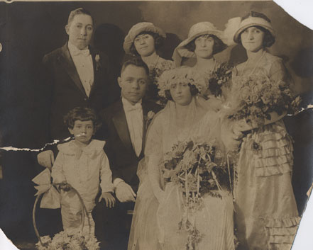 Faded photograph with cracks in the image and frayed edges